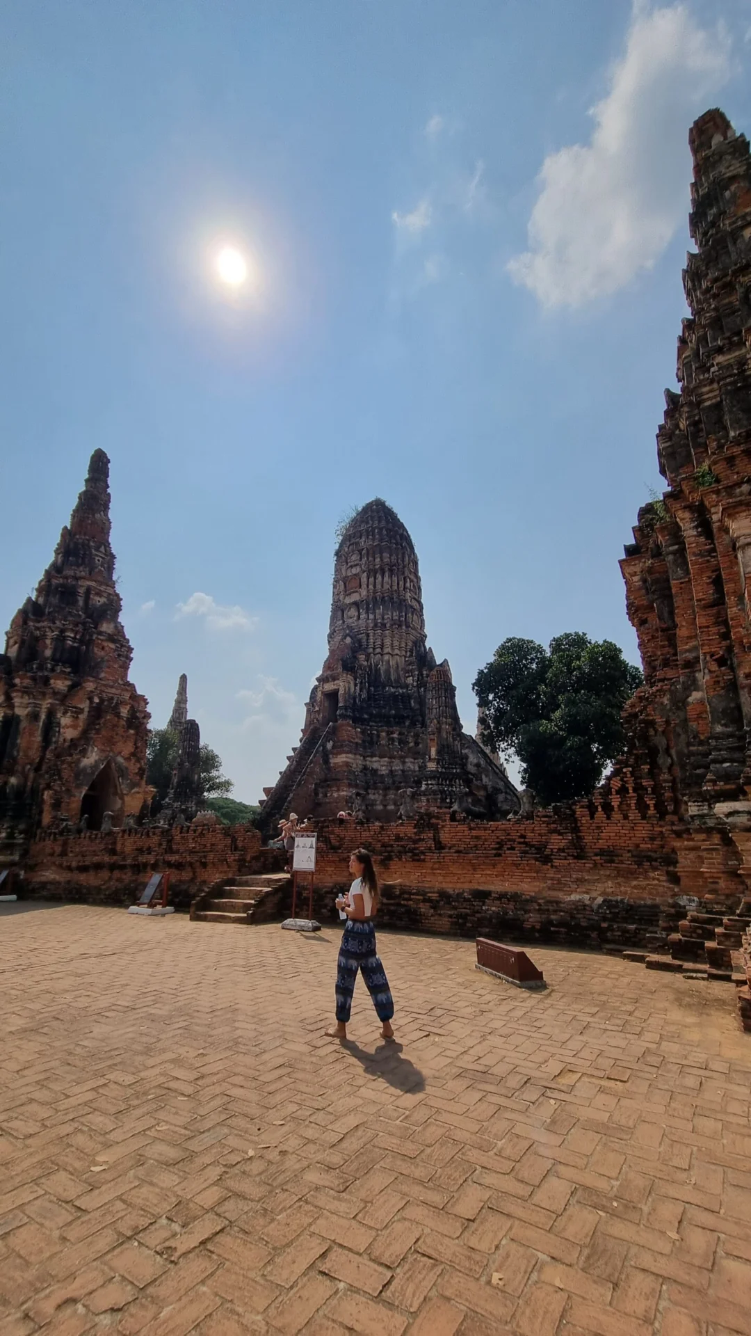 Ruined temple towers rise around a sunlit courtyard in Ayutthaya Historical Park.