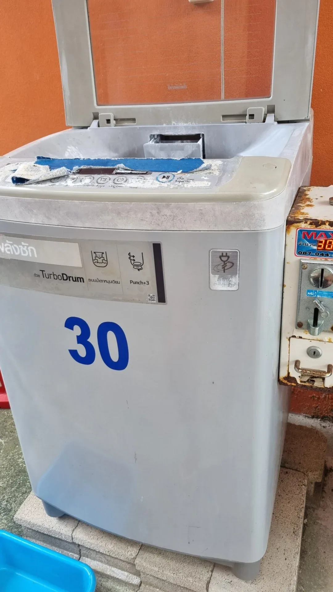 Coin-operated washing machine with a large blue number 30 on the front.